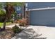 Charming blue home with stone accents on a three-car garage and mature landscaping at 2736 Suncoast Lakes Blvd, Punta Gorda, FL 33980