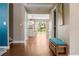 Hallway view leading to living area and lush backyard, featuring wood floors and a cozy bench at 2736 Suncoast Lakes Blvd, Punta Gorda, FL 33980