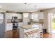 Bright kitchen with stainless steel appliances, granite countertops, white cabinets, and island with seating at 2736 Suncoast Lakes Blvd, Punta Gorda, FL 33980