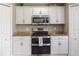 Close-up of the stainless steel oven and microwave, granite countertops, and white cabinets in the kitchen at 2736 Suncoast Lakes Blvd, Punta Gorda, FL 33980