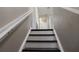 Stairway with brown treads, white risers and handrail leads upstairs from the main level of the home at 2736 Suncoast Lakes Blvd, Punta Gorda, FL 33980