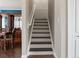 Stairway with brown treads, white risers and handrail leads upstairs from the main level of the home at 2736 Suncoast Lakes Blvd, Punta Gorda, FL 33980