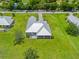 Aerial view of a bright home with a new roof surrounded by a large green yard and mature landscaping at 28960 Gin Ln, Punta Gorda, FL 33982