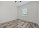 This bright bedroom features stylish wood-look floors and a large window at 28960 Gin Ln, Punta Gorda, FL 33982