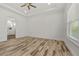 Large bedroom with wood-style flooring, ceiling fan and a door to the bathroom at 28960 Gin Ln, Punta Gorda, FL 33982