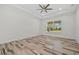 Bright bedroom with wood-style flooring, ceiling fan, and a large window with blinds at 28960 Gin Ln, Punta Gorda, FL 33982