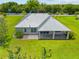 Lush yard with mature trees surrounds this home, with a view of the patio and outdoor living space at 28960 Gin Ln, Punta Gorda, FL 33982