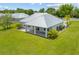 This exterior features a well-manicured yard, a metal roof, and an outdoor living space on the back patio at 28960 Gin Ln, Punta Gorda, FL 33982