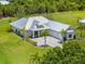Beautifully landscaped home featuring a metal roof, well-manicured lawn, and a paver driveway at 28960 Gin Ln, Punta Gorda, FL 33982