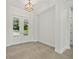 Bright foyer with double doors, tile floors, and custom lighting fixture at 28960 Gin Ln, Punta Gorda, FL 33982