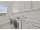 An organized laundry room features stone countertops and washer and dryer at 28960 Gin Ln, Punta Gorda, FL 33982