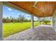A covered patio area has a wood ceiling, pavers, and bright natural light for outdoor living at 28960 Gin Ln, Punta Gorda, FL 33982