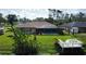 Spacious backyard with screened in pool, lush landscaping, and fire pit near the water's edge at 319 Kindred Blvd, Port Charlotte, FL 33954