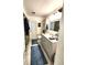 Bright bathroom featuring a shower with leaf curtains, vanity, and toilet with white door to exterior at 319 Kindred Blvd, Port Charlotte, FL 33954