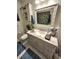 Bathroom featuring a granite topped vanity, decorative mirror, and leaf shower curtain at 319 Kindred Blvd, Port Charlotte, FL 33954