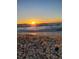 Scenic beach view at sunset with seashells scattered on the sand and gentle waves rolling in at 319 Kindred Blvd, Port Charlotte, FL 33954
