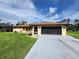Charming home featuring a well-maintained lawn, a neutral color scheme, and a spacious screened garage at 319 Kindred Blvd, Port Charlotte, FL 33954