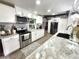 A bright kitchen featuring white cabinets, stainless steel appliances, and granite countertops at 319 Kindred Blvd, Port Charlotte, FL 33954