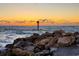 Ocean view at sunset with rocks and a channel marker, capturing the beauty of the coastline at 319 Kindred Blvd, Port Charlotte, FL 33954