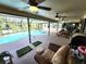 Covered patio boasts ceiling fans, comfortable seating, a grill, and a screened-in pool at 319 Kindred Blvd, Port Charlotte, FL 33954