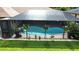Screened-in pool with heart shape, hanging plants, and garden statues in a well maintained fenced-in yard at 319 Kindred Blvd, Port Charlotte, FL 33954