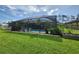 Screened-in pool with heart shape, hanging plants, and lush landscaping in fenced-in yard at 319 Kindred Blvd, Port Charlotte, FL 33954