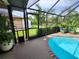 Screened in pool with brick trim and lush landscaping in an enclosed patio at 319 Kindred Blvd, Port Charlotte, FL 33954