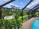 Screened-in pool and waterfront view with landscaped garden along the patio at 319 Kindred Blvd, Port Charlotte, FL 33954