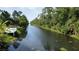 Scenic canal view with lush greenery and private dock access, perfect for boating and enjoying waterfront living at 319 Kindred Blvd, Port Charlotte, FL 33954