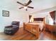 Spacious bedroom with hardwood floors, ceiling fan, comfy chair, and bright natural light at 3456 Highlands Rd, Punta Gorda, FL 33983