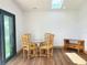 Bright dining area featuring wood floors, a glass table with seating and a skylight at 3456 Highlands Rd, Punta Gorda, FL 33983