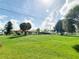 Charming single-story home with a large front lawn and mature trees under a partly cloudy sky at 3456 Highlands Rd, Punta Gorda, FL 33983