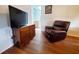 Living room with hardwood floors, a dresser, a TV and a cozy leather recliner at 3456 Highlands Rd, Punta Gorda, FL 33983