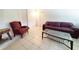 Living area features tile floors, a leather sofa and an accent chair, and a glass coffee table at 3456 Highlands Rd, Punta Gorda, FL 33983