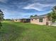 Backyard with green grass, screened in patio, and white picket fence on perimeter at 3512 Nekoosa St, North Port, FL 34287