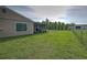 View of a large backyard featuring a screened-in porch and chain-link fence at 3512 Nekoosa St, North Port, FL 34287