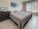 Cozy bedroom featuring a large window, wood-look floors, and neutral color palette at 3512 Nekoosa St, North Port, FL 34287