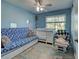 Bright bedroom featuring a sofa, crib, and neutral-toned carpet flooring at 3512 Nekoosa St, North Port, FL 34287