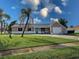 Charming single-story home with a blue front door, lush lawn, and attached one car garage at 3512 Nekoosa St, North Port, FL 34287