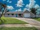 Charming single-story home with a blue front door, lush lawn, and attached one car garage at 3512 Nekoosa St, North Port, FL 34287