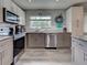 Updated kitchen with stainless steel appliances, gray cabinets, and wood-look flooring at 3512 Nekoosa St, North Port, FL 34287