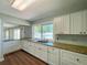 Bright kitchen area featuring white cabinets, granite countertops, stainless steel sink, and wood floors at 3512 Nekoosa St, North Port, FL 34287