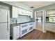 Clean kitchen featuring white cabinets, dual ovens and stovetops, and wood-look flooring at 3512 Nekoosa St, North Port, FL 34287