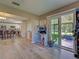 Open living room with view of the kitchen, a sliding door to patio and laminate wood flooring at 3512 Nekoosa St, North Port, FL 34287