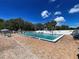 Community pool with brick patio, white fencing and plenty of lounge chairs under a bright blue sunny sky at 3512 Nekoosa St, North Port, FL 34287