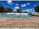 Swimming pool surrounded by lounge chairs, palm trees, and a white fence, perfect for relaxation and recreation at 3512 Nekoosa St, North Port, FL 34287