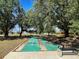 A shuffleboard court area is surrounded by beautiful mature trees in a park-like setting at 3512 Nekoosa St, North Port, FL 34287