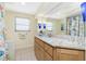 Bright bathroom with granite counters, wood cabinets, and a shower featuring decorative fish curtain at 4051 Rock Creek Dr, Port Charlotte, FL 33948