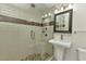 Modern bathroom featuring a glass-enclosed shower with tiled walls and a pedestal sink at 415 W Marion Ave, Punta Gorda, FL 33950