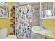 Bright bathroom with colorful shower curtain, sink and mirror, and built-in shelves at 415 W Marion Ave, Punta Gorda, FL 33950